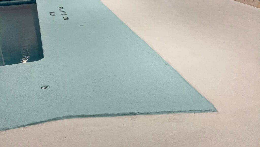 Pools & Decks 7 Freshly resurfaced indoor pool deck—finished surface, blue and white, “NO DIVING” text barely visible