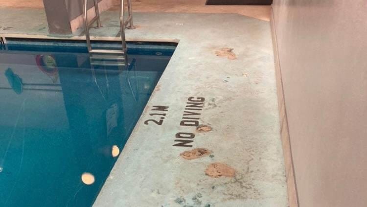 Pools & Decks 6 Pool deck, close-up, before resurfacing—peeling spots, stains, visible “NO DIVING”.